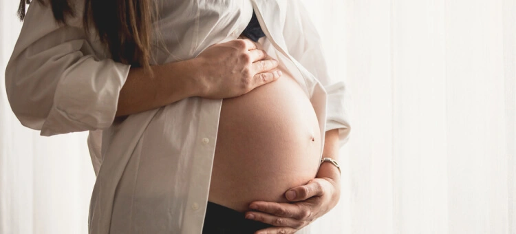 Kobieta w ciąży trzymająca brzuch – objawy i diagnostyka zaśniadu groniastego