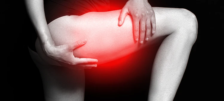 Kobieta cierpi na ból uda, oznaczony czerwonym światłem