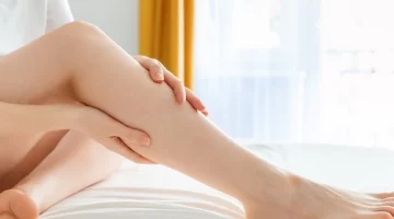 Kobieta masuje swoje nogi w celu sprawdzenia objawów zakrzepicy