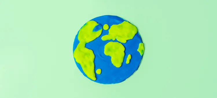 Płaski model Ziemi z zielonej i niebieskiej plasteliny na jasnozielonym tle