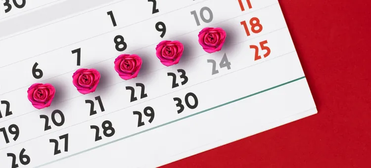 Kalendarz menstruacyjny kobiety do obserwacji dni menstruacji, na czerwonym tle z dniami menstruacji oznaczonymi różami