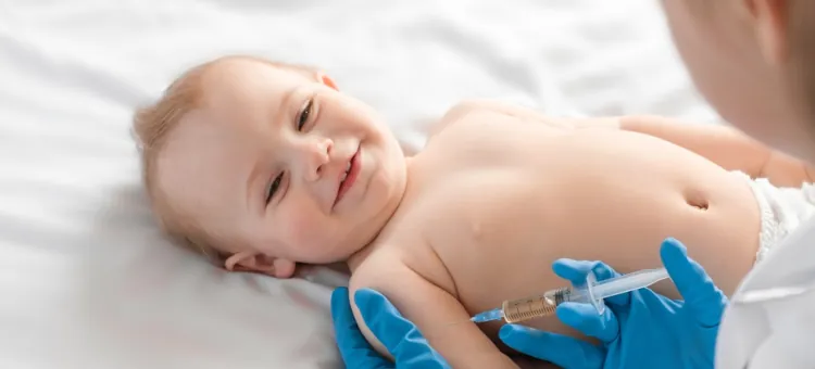 Lekarz pediatra podaje szczepionkę małemu uśmiechniętemu dziecku