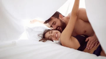 Kobieta i mężczyzna leżą razem w łóżku pod białą kołdrą