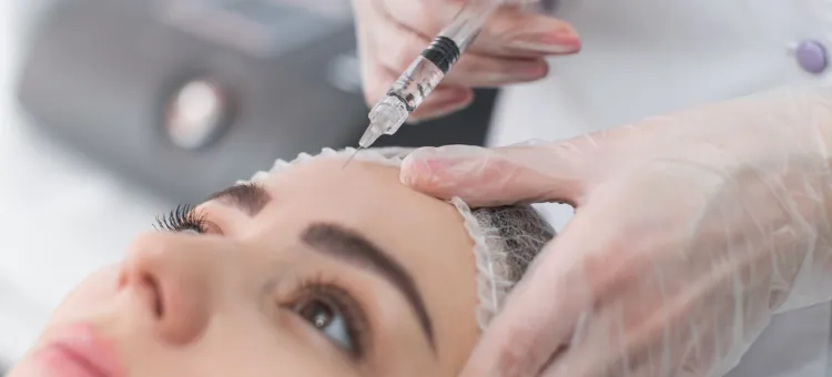 Kobieta otrzymuje zastrzyk botoksu do twarzy w salonie kosmetycznym