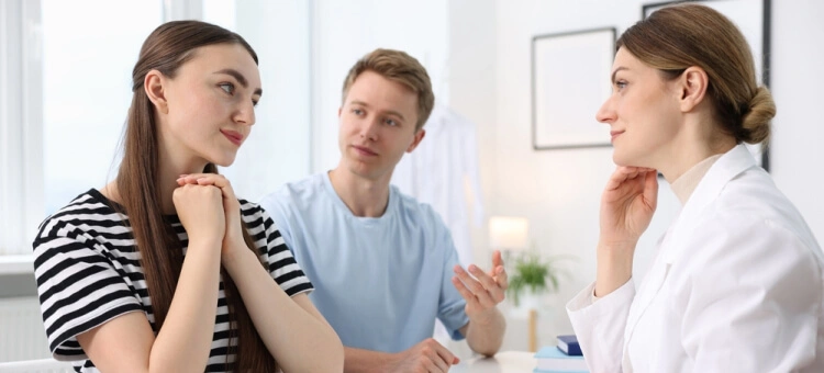 Para rozmawiająca z lekarką podczas konsultacji dotyczącej planowania ciąży w klinice leczenia niepłodności