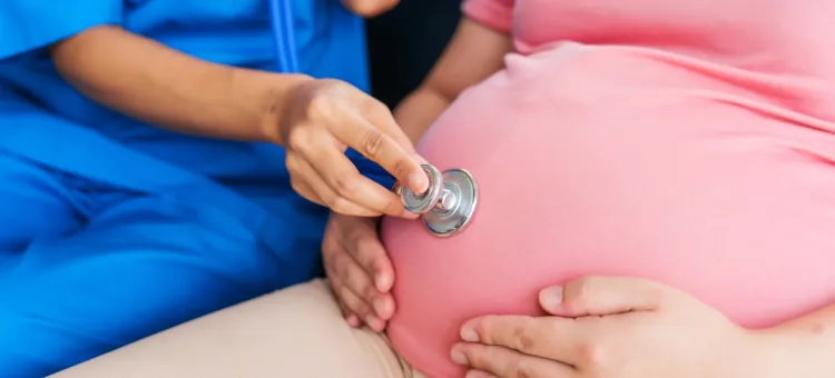 Lekarka bada stetoskopem brzemienną pacjentkę