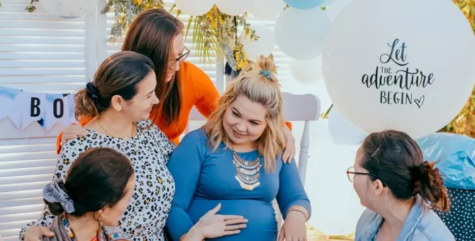 Radosne grono kobiet wspiera przyszłą mamę podczas baby shower z okazji przyjścia na świat maluszka