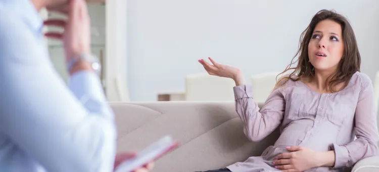 Przyszła mama, z zatroskaną miną, dzieli się swoimi uczuciami podczas spotkania w gabinecie psychiatrycznym