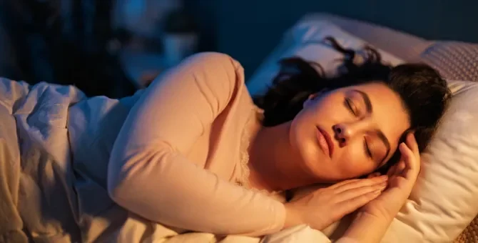 Cichy sen ogarnia kobietę z głową na poduszce, w czasie nocnej ciszy