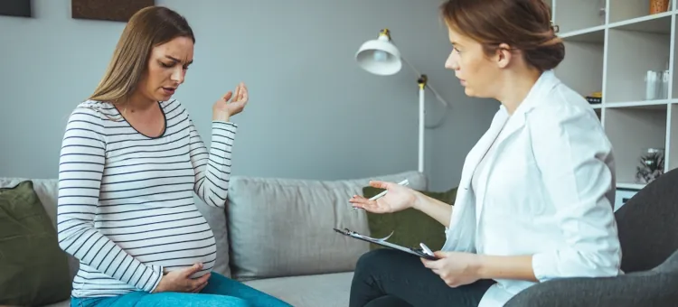 Kobieta w ciąży wyraża swoje obawy podczas konsultacji ze specjalistką