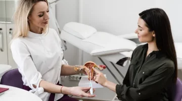 Specjalistka tłumaczy pacjentce funkcjonowanie spirali antykoncepcyjnej na modelu anatomicznym układu rozrodczego