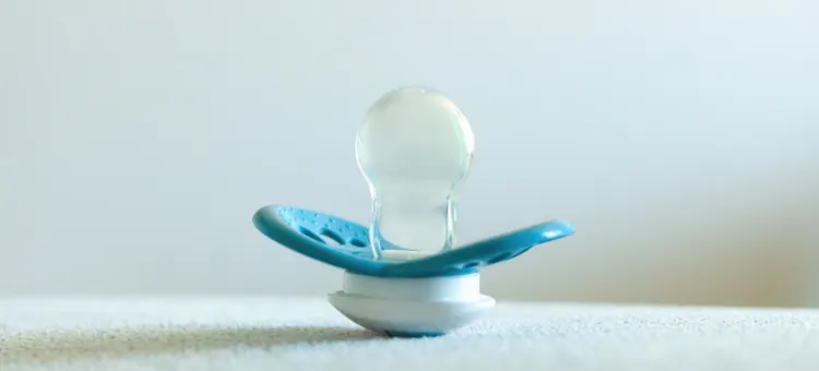 Delikatny gryzak o kojącym działaniu w odcieniach błękitu stoi na białej powierzchni