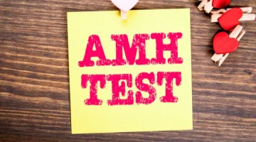 Żółta karteczka samoprzylepna z napisem AMH, obrazująca wyniki badań hormonalnych, determinujących kobiecy potencjał rozrodczy