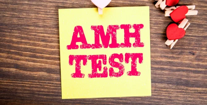 Żółta karteczka samoprzylepna z napisem AMH, obrazująca wyniki badań hormonalnych, determinujących kobiecy potencjał rozrodczy