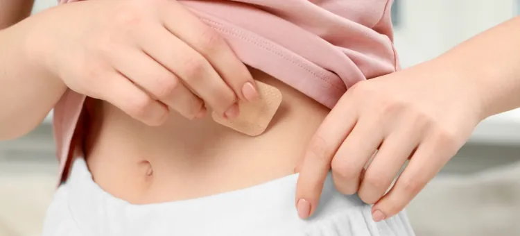 Kobieta delikatnie nakładająca niewielki antykoncepcyjny przylepiec na skórę swojego brzucha