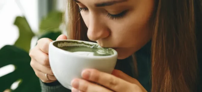 Kobieta delektuje się aromatyczną matchą w jasnym wnętrzu