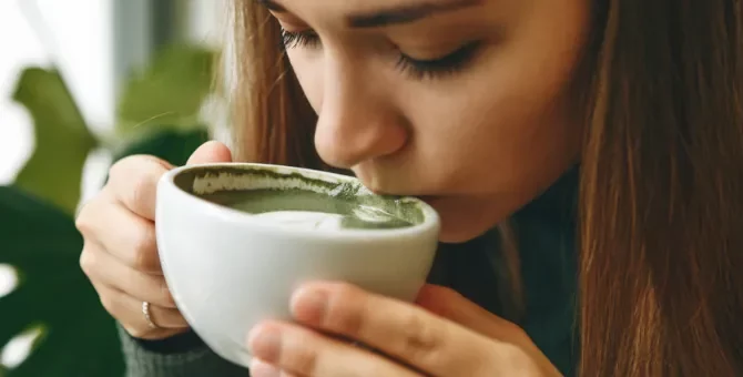 Kobieta delektuje się aromatyczną matchą w jasnym wnętrzu