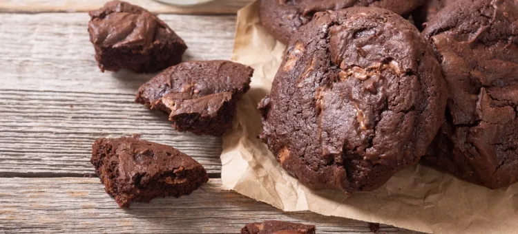Czekolada, bakalie i świąteczny smak – pomysły na pyszne wypieki dla Mikołaja Apetyczne, kakaowe ciastka na starym drewnianym stole