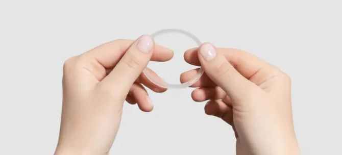 Kobiece dłonie trzymają elastyczny, jasny antykoncepcyjny krążek dopochwowy