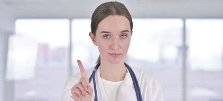 Przeciwwskazania do stosowania pierścienia dopochwowego Lekarka z poważną miną unosi palec wskazujący, wyrażając stanowczą przestrogę