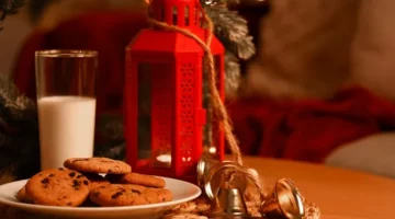 Urokliwy czas Bożego Narodzenia z ciasteczkami i napojem mlecznym i czerwoną latarenką na stole