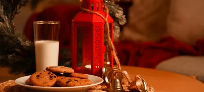 Urokliwy czas Bożego Narodzenia z ciasteczkami i napojem mlecznym i czerwoną latarenką na stole