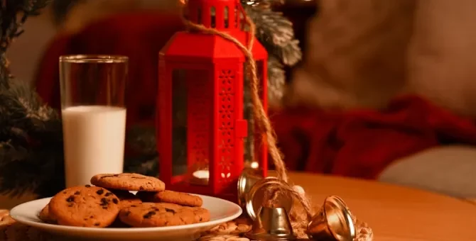Urokliwy czas Bożego Narodzenia z ciasteczkami i napojem mlecznym i czerwoną latarenką na stole