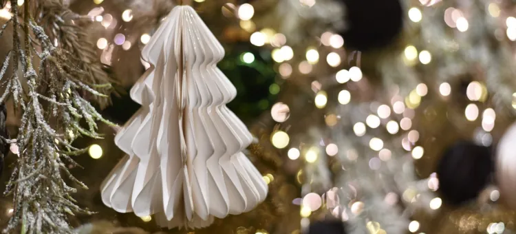 Proste ozdoby świąteczne z papieru na Boże Narodzenie Białe harmonijkowe drzewko zawieszone wśród migoczących lampek i gałązek