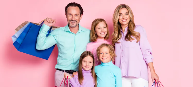 Ogólnopolski system zniżek KDR – FAQ Rodzice wraz z dziećmi z zadowoleniem pozują do zdjęcia, trzymając torby zakupowe