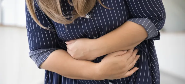 Młoda osoba doświadcza silnego dyskomfortu w okolicy brzucha