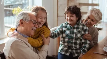Szczęśliwi dziadkowie i dzieci przy stole