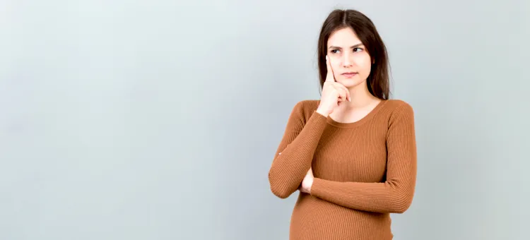 Młoda osoba w ciąży zadumana nad różnymi możliwościami