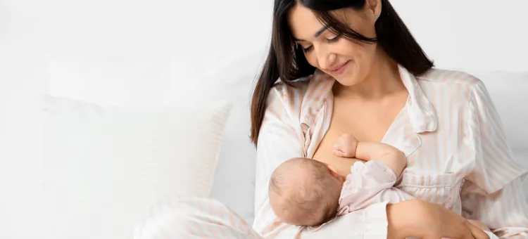 Młoda matka na jasnym tle z czułością zapewnia pokarm swojemu nowo narodzonemu dziecku, karmiąc piersią