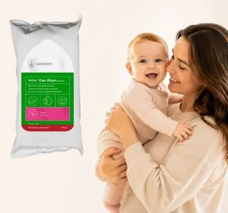 Opakowanie chusteczek Velox Duo Wipes do dezynfekcji powierzchni oraz uśmiechnięta mama trzymająca niemowlę